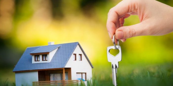 depositphotos_24613763-stock-photo-hand-holding-key-against-house